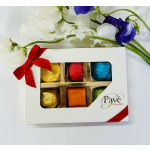 Box of assorted chocolates with a red ribbon and white flowers