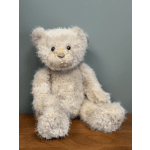 Plush teddy bear sitting on a wooden surface