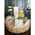 Gift basket with yellow flowers, decorative plates, and assorted packaged items