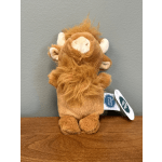 Small plush lion toy with a tag, sitting on a wooden surface