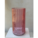 Pink ribbed glass vase on a white surface