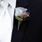 White calla lily boutonniere pinned to a black suit jacket