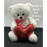 White teddy bear holding a red heart pillow