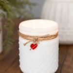 White textured candle jar with twine and a red heart charm