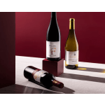 Three wine bottles arranged on a burgundy and white surface
