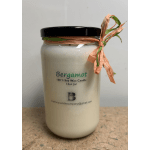 Cream soy wax candle in a glass jar with a black lid and ribbon tie