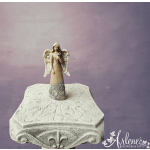 Angel figurine holding a rose on an ornate pedestal