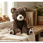 Brown teddy bear plush sitting on a cream knit blanket