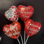 Four heart-shaped Valentine balloons with white sticks