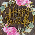 Gold "Happy Birthday" sign with pink flowers and green leaves