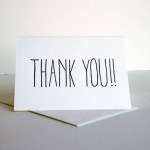 A white thank-you card standing on a table.