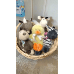 Basket of plush farm animals including a duck, cow, rhino, and dog