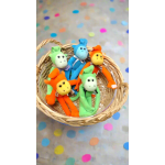 Basket of colorful plush monkey toys on a polka dot background