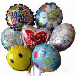 Cluster of colorful birthday and love-themed balloons, including a smiley face balloon