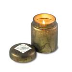 Lit candle in a metallic jar with a matching lid beside it