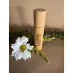White daisy with greenery beside a bamboo tube engraved "HAPPY"
