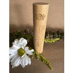 White daisy with greenery beside a bamboo tube container