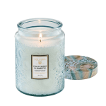 Lit glass candle jar with patterned lid