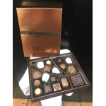 Box of assorted chocolates with a copper gift box behind it