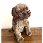 Brown plush puppy sitting on a wooden surface
