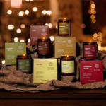 Assorted scented candles and boxed wax melts arranged on fabric