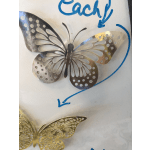 Metal butterfly wall decor with cutout wings and blue marker arrows