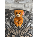 Small brown plush teddy bear sitting on a decorative metal table