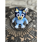 Blue plush dog toy sitting on a decorative metal table