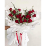 Bouquet of red roses wrapped in white paper with a ribbon
