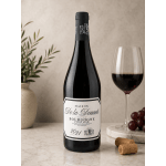 Bottle of red wine beside a glass of wine and grapes