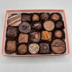 Box of assorted chocolate candies in paper cups