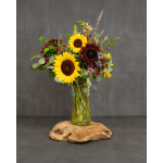 Sunflower bouquet in a clear glass vase on a wooden base
