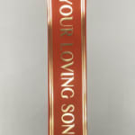 Red ribbon with gold text on a plain background