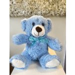 Blue teddy bear with a turquoise ribbon sitting on a table
