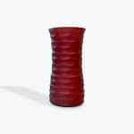 Red textured glass vase on a white background