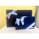Two navy gift boxes with white ribbon bows on a table