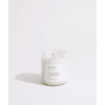 White candle in a clear glass jar with a lit wick