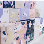 Display of pastel greeting cards with floral designs and gold lettering