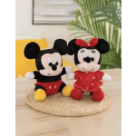 Two Mickey and Minnie plush toys sit on a woven mat.