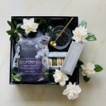Gift box with white flowers, coffee, macarons, and a glass cup