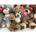 Plush stuffed animals with red gift tags are piled together