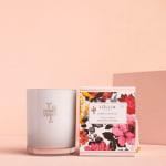 A scented candle beside a floral-patterned candle box