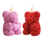 Two rose-covered teddy bear candles, one pink and one red, with flames lit on top