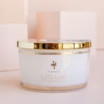 White scented candle in a glass jar with a gold lid