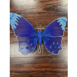 Purple decorative butterfly with blue glitter accents on a wooden surface