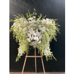 Large white orchid arrangement on a wooden easel