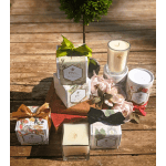 Gift set with candles, floral boxes, and pale pink roses on a wooden table