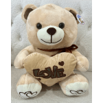 Plush teddy bear holding a heart with the word LOVE