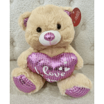 Plush teddy bear holding a pink sequined heart