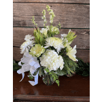 White floral arrangement in a clear glass vase with a white ribbon